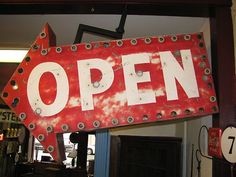 an open sign hanging from the side of a building