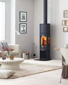 a living room filled with furniture and a fire place in the middle of the room