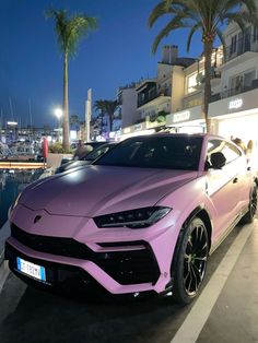 a pink sports car parked in front of a marina