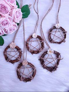 three pieces of wicker hanging from strings with pink roses in the background on a white furnishing