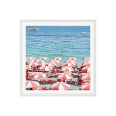 the beach is full of red and white umbrellas with boats in the water behind them