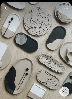 many different shapes and sizes of plates on a wooden table with black and white designs