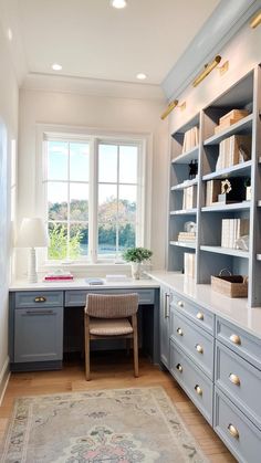 a home office with built - in shelving units and a rug on the floor