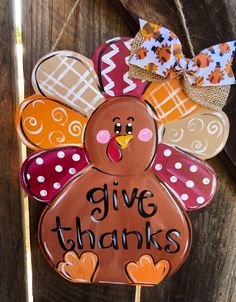 a hand painted turkey on a stick that says give thanks