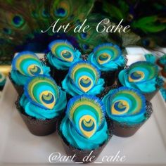 cupcakes with blue and yellow frosting are arranged in the shape of peacock feathers