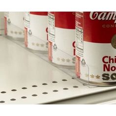 cans of soup are lined up on the shelf