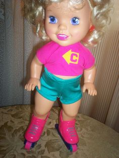 a doll with blonde hair and blue eyes is standing on a bed wearing pink boots