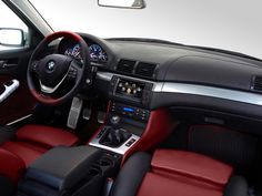 the interior of a car with red and black leather trims, steering wheel, dash lights, and dashboard controls