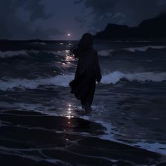 a woman walking along the beach at night with her back to the camera, looking out into the ocean