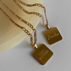 Square pendant necklace with text "Fearless" in the middle of the pendant. Figaro chain. Minimal and timeless design. ………………………………….D E T A I L S• Materials: Stainless steel, 18k gold plating.• Chain length:16 inches (40 cm) + extension 2 inches (5 cm)• Pendant dimension: 0.8 inches * 0.8 inches (2 cm * 2 cm)• This product is hypoallergenic, water and tarnish resistant Gold Pendant Charm Necklace For Friendship, Fearless Necklace, Square Pendant Necklace, Contemporary Fine Jewelry, Square Necklace, Figaro Chains, Figaro Chain, Minimal Jewelry, Square Pendant