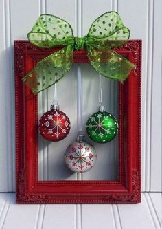 christmas ornaments are hanging in a red frame with green bow on it's head