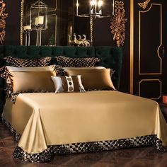 a bed with gold sheets and pillows in a room that has black walls, chandelier and mirror