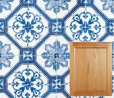 a blue and white tiled wall with wooden cabinet in the middle, next to it