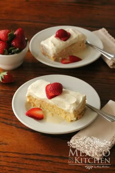 two plates with slices of cake and strawberries