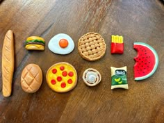 a wooden table topped with different types of toy food and toys on top of it