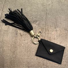 a black leather keychain with a tassel hanging from it