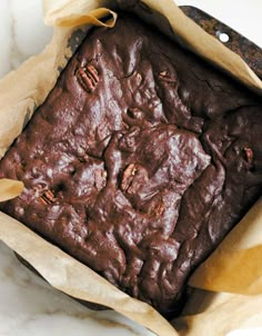 a brownie in a paper bag on top of a marble counter with a knife