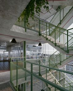 an indoor stair case with green railing and metal handrails in a large office building