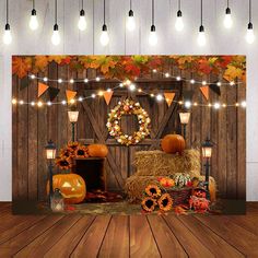 an autumn scene with pumpkins, hay bales and lights hanging from the ceiling