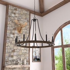 a chandelier hanging from the ceiling in a room with stone walls and windows