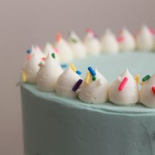 a birthday cake with white frosting and colorful sprinkles on the top