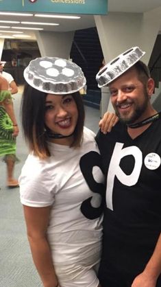 two people standing next to each other with hats on their heads