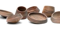 several wooden bowls and spoons on a white background