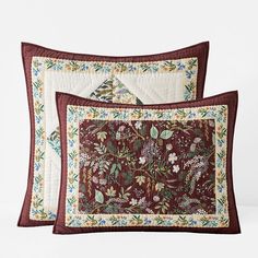 two pillow cases with red and green floral designs on them, one has a quilted border