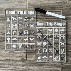 the road trip bingo game is laid out on a wooden table with a knife and scissors