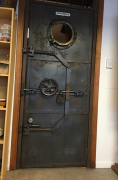 an old door with a porthole in the middle and metal bars on both sides