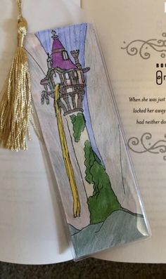 a bookmark with an image of a castle on it and a tassel hanging from it