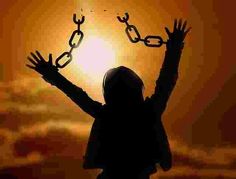 the silhouette of a person with their hands in the air and chains hanging from them