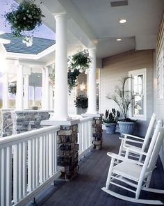 a white rocking chair sitting on top of a wooden porch