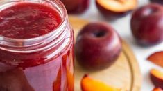 a jar filled with liquid next to sliced peaches