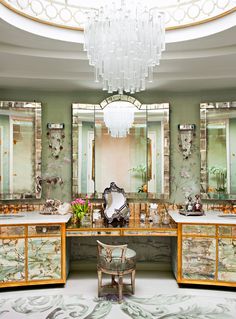 a fancy bathroom with chandelier and marble counter tops in an ornately decorated room