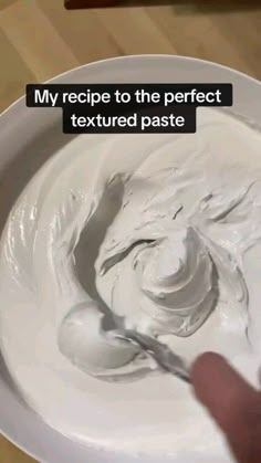 a person is mixing white cream in a bowl