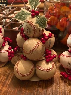 several baseballs are stacked on top of each other with holly leaves and berries around them