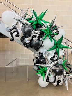 a bunch of balloons that are sitting on some kind of stair case in front of a wall