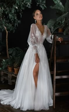 a woman in a white dress standing next to a potted plant and wearing high heels