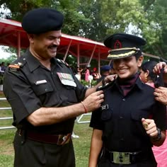 a man in uniform standing next to a woman