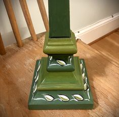 a green vase sitting on top of a wooden floor