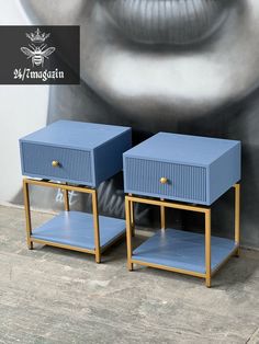 two blue nightstands sitting next to each other in front of a wall with a painting on it