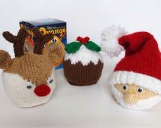 three knitted christmas hats with reindeer noses and nose on them, next to a box of nutcrackers