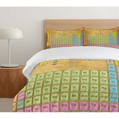 an image of a bedroom setting with the bed cover and pillowcases covered in chemical symbols