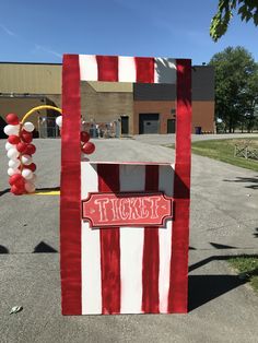 a red and white striped mailbox sitting in the middle of a parking lot