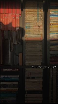 the shadow of a person standing in front of a bookshelf filled with books