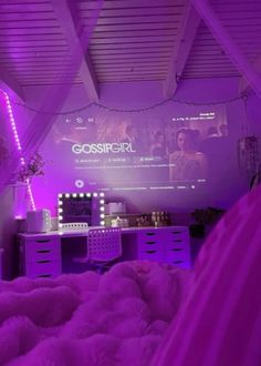 a bedroom with purple lighting and a bed covered in blankets, pillows and rugs