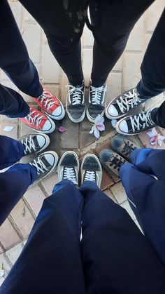 several people standing in a circle wearing tennis shoes