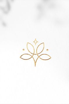 a white background with a gold design on the front and back of it, which has a small diamond in the middle