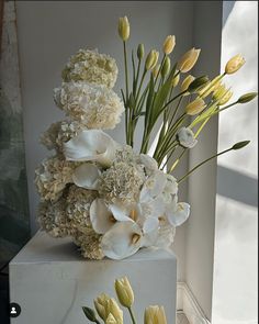 a vase filled with white and yellow flowers